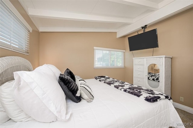 bedroom featuring vaulted ceiling with beams and baseboards