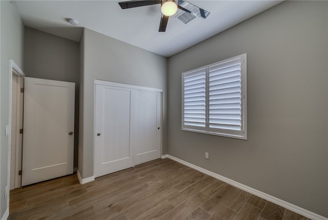 2339 E Calle Madrid, Fort Mohave, AZ 86426 - unfurnished bedroom with wood finished floors, baseboards, a closet, and a ceiling fan