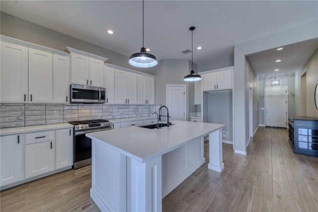 2339 E Calle Madrid, Fort Mohave, AZ 86426 - kitchen featuring stainless steel appliances, a sink, white cabinets, backsplash, and light countertops