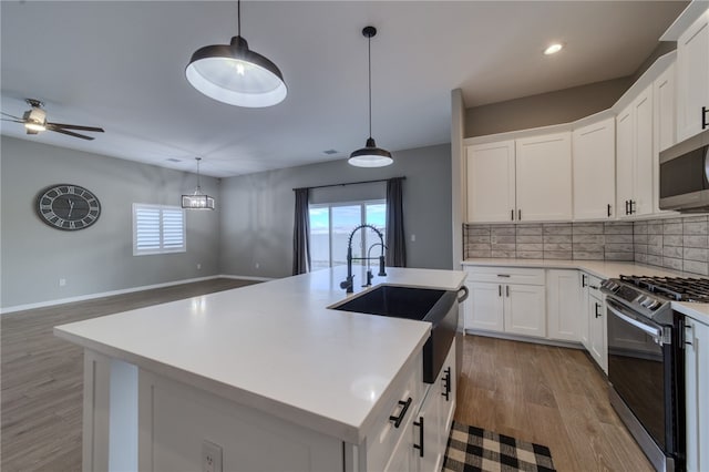 2339 E Calle Madrid, Fort Mohave, AZ 86426 - kitchen with appliances with stainless steel finishes, a sink, light wood finished floors, backsplash, and light countertops