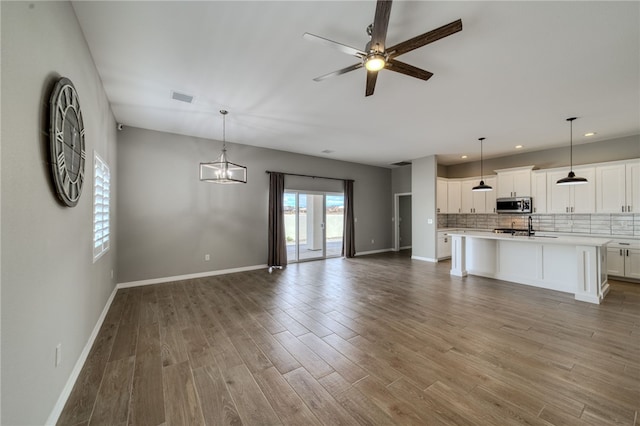 2339 E Calle Madrid, Fort Mohave, AZ 86426 - unfurnished living room with recessed lighting, a ceiling fan, baseboards, wood finished floors, and a sink