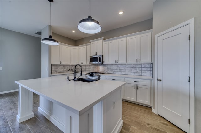 2339 E Calle Madrid, Fort Mohave, AZ 86426 - kitchen with appliances with stainless steel finishes, a sink, light wood-style floors, white cabinetry, and recessed lighting