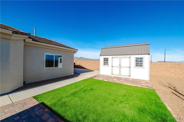 view of yard with a shed, fence, and an outdoor structure