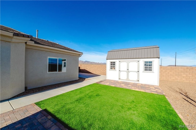 view of yard featuring a fenced backyard, a storage shed, and an outbuilding