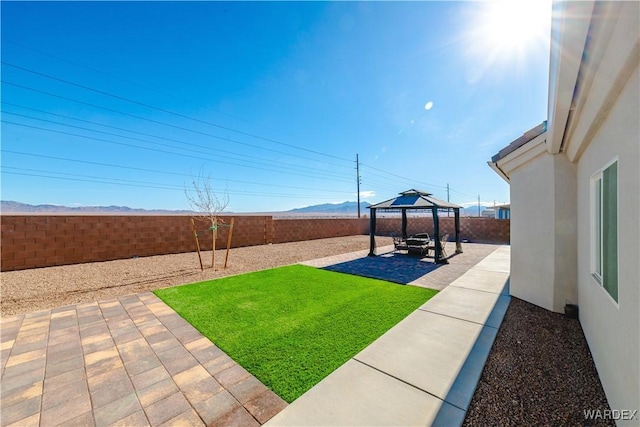 view of yard featuring a gazebo, a patio, a fenced backyard, and a mountain view