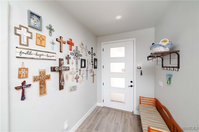 doorway featuring light wood-type flooring and baseboards