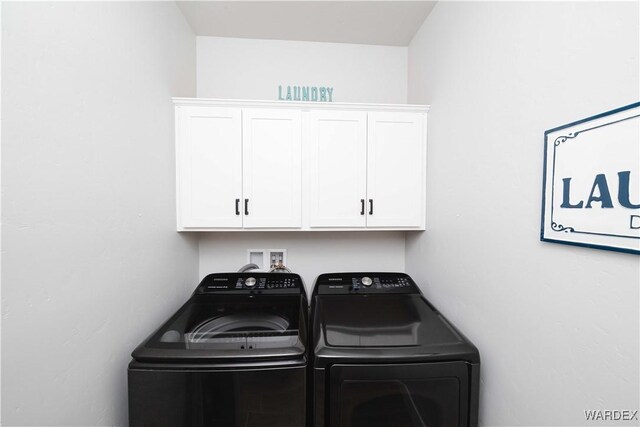 clothes washing area with washing machine and clothes dryer and cabinet space