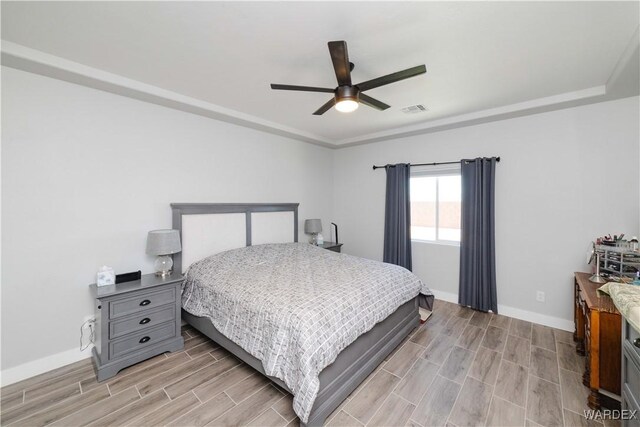 bedroom with baseboards, visible vents, a ceiling fan, and wood finish floors