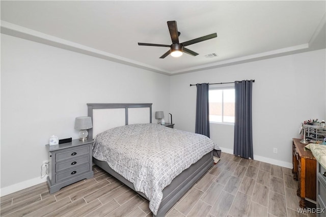 bedroom featuring visible vents, baseboards, ceiling fan, and wood tiled floor