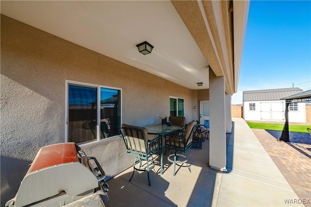 view of patio featuring a shed, an outbuilding, and outdoor dining space