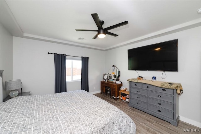 bedroom featuring visible vents, baseboards, a ceiling fan, and wood finish floors
