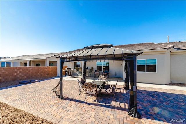 view of patio with outdoor dining area, a gazebo, and fence