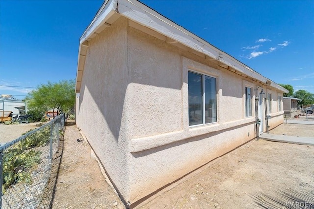 view of home's exterior featuring fence and stucco siding