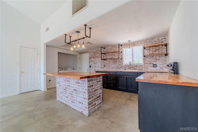 kitchen featuring visible vents, hanging light fixtures, finished concrete floors, open shelves, and wooden counters