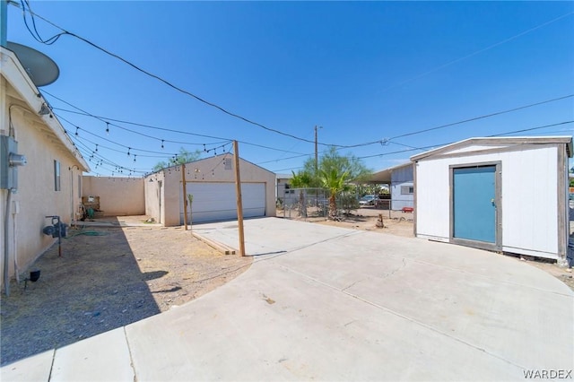 exterior space featuring a garage, an outdoor structure, and fence