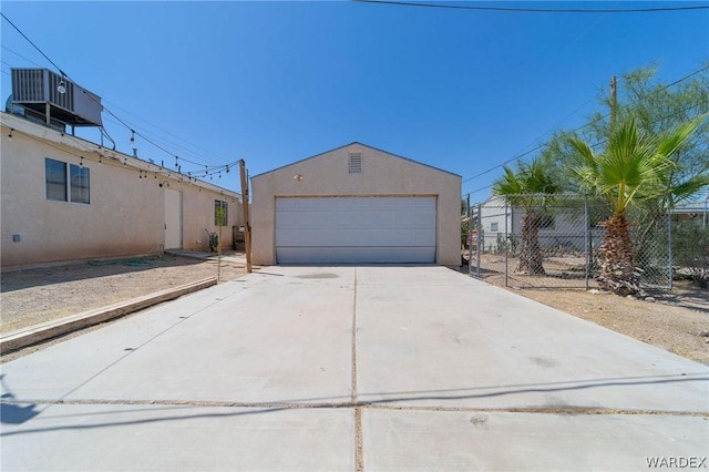 view of front of home featuring a garage, central AC unit, fence, and stucco siding