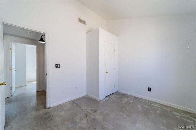 unfurnished bedroom with visible vents, concrete floors, and baseboards