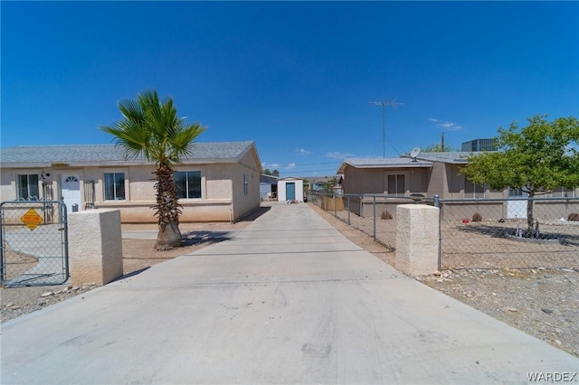 view of front of property featuring a fenced front yard, concrete driveway, and stucco siding