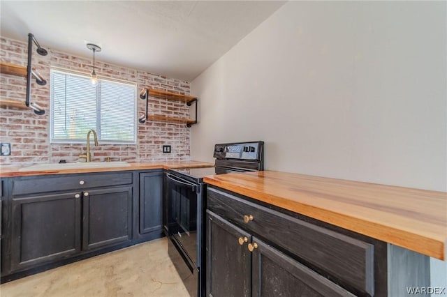 kitchen with brick wall, hanging light fixtures, black range with electric cooktop, and wood counters