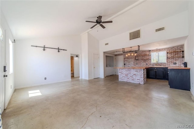 kitchen with wood counters, visible vents, open floor plan, and a sink