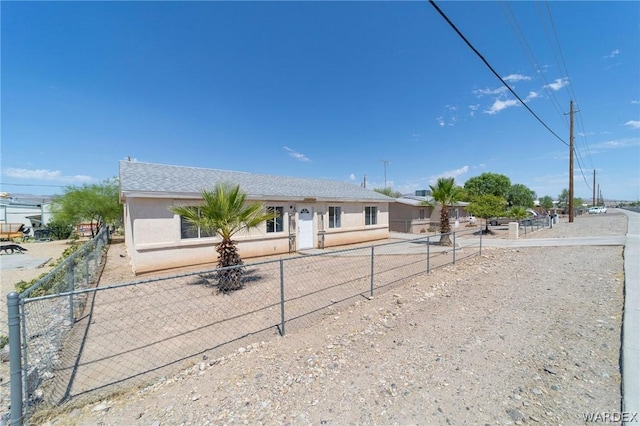 ranch-style house with a fenced front yard and stucco siding