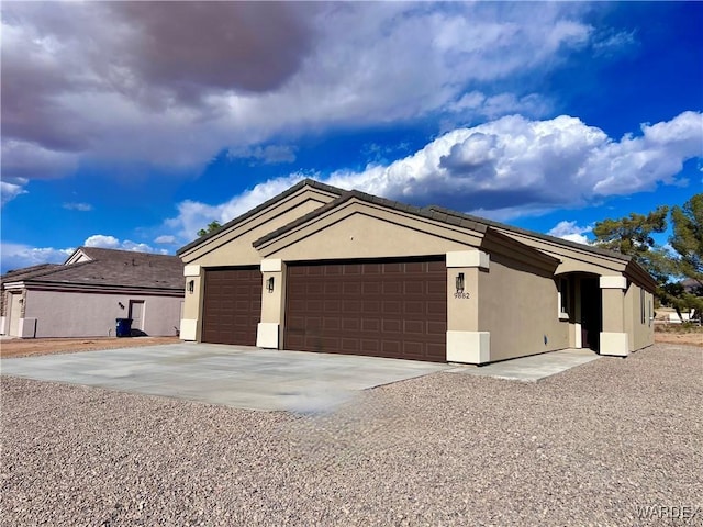 9882 N La Jolla Dr, Kingman, AZ 86401 - view of front of house with concrete driveway, a garage, and stucco siding