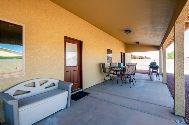 view of patio / terrace featuring a grill, fence, and outdoor dining space