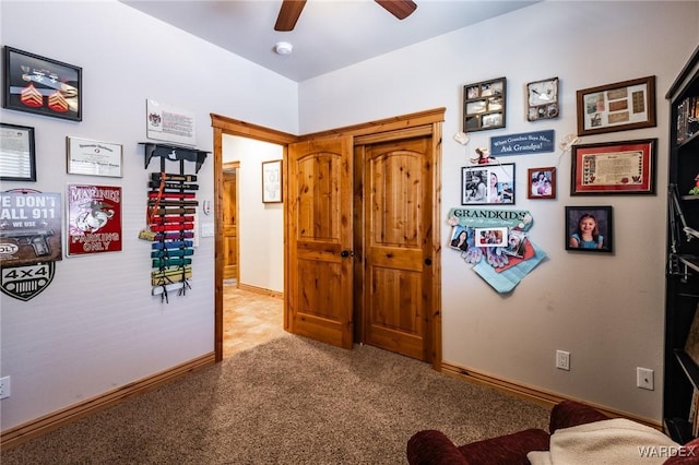 interior space featuring baseboards, ceiling fan, and carpet floors
