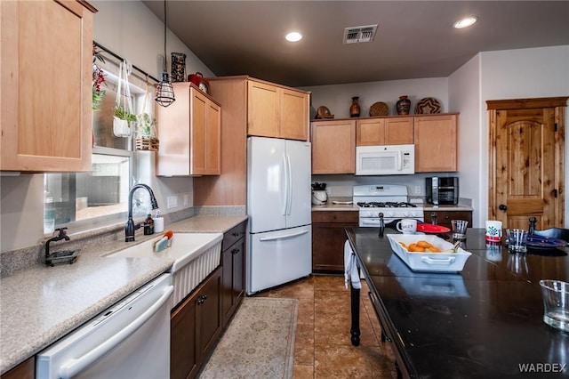 kitchen featuring recessed lighting, white appliances, hanging light fixtures, a sink, and visible vents