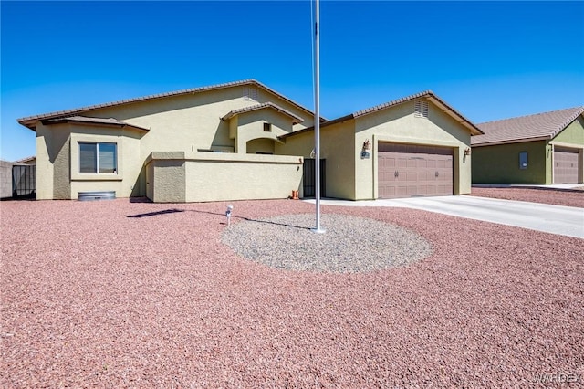 ranch-style house featuring a garage, fence, stucco siding, and concrete driveway
