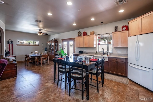 kitchen with visible vents, a healthy amount of sunlight, light countertops, and freestanding refrigerator