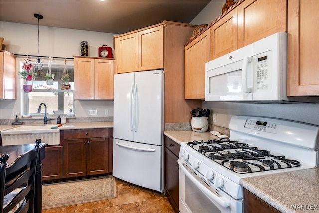 kitchen featuring pendant lighting, white appliances, light countertops, and a sink