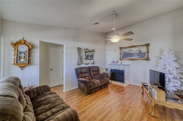 3408 Sunriver Rd Unit 207 B6, Bullhead City, AZ 86429 - living area with a tile fireplace, light wood-style floors, ceiling fan, and baseboards