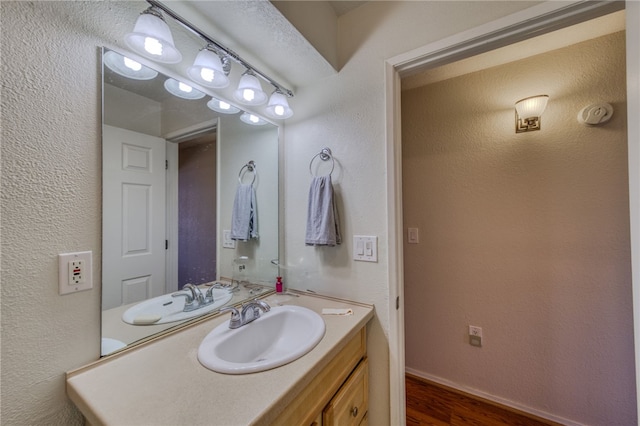 3408 Sunriver Rd Unit 207 B6, Bullhead City, AZ 86429 - bathroom featuring wood finished floors, vanity, baseboards, and a textured wall