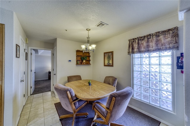 3408 Sunriver Rd Unit 207 B6, Bullhead City, AZ 86429 - dining space with a chandelier, a textured ceiling, light tile patterned flooring, baseboards, and light colored carpet