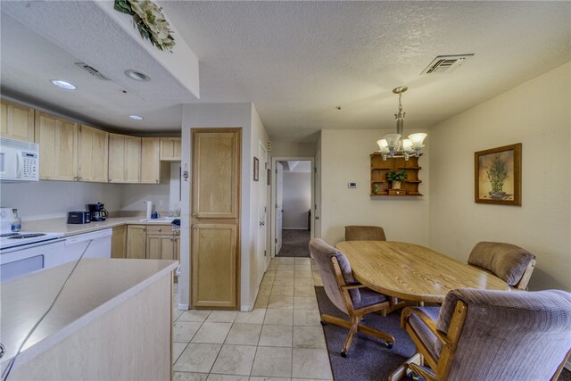 3408 Sunriver Rd Unit 207 B6, Bullhead City, AZ 86429 - kitchen featuring white microwave, light brown cabinetry, light countertops, a chandelier, and a textured ceiling