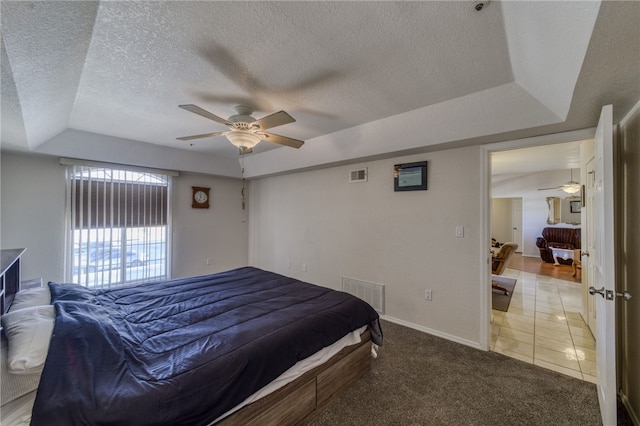 3408 Sunriver Rd Unit 207 B6, Bullhead City, AZ 86429 - bedroom with a raised ceiling, a textured ceiling, light colored carpet, baseboards, and light tile patterned floors