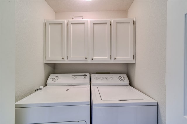 3408 Sunriver Rd Unit 207 B6, Bullhead City, AZ 86429 - washroom featuring cabinet space, washer and dryer, a textured wall, and a textured ceiling