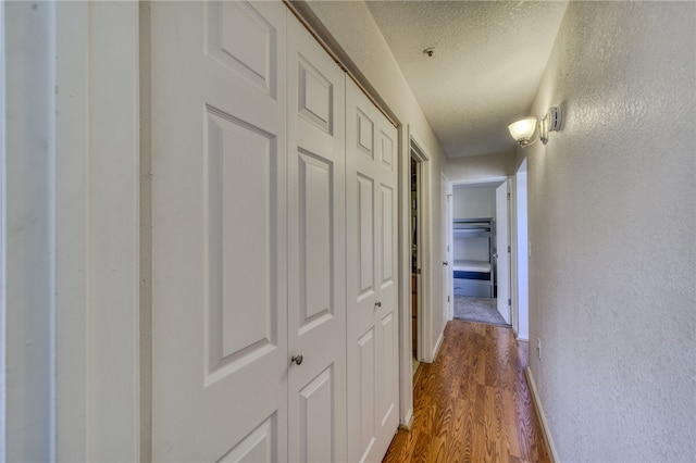 3408 Sunriver Rd Unit 207 B6, Bullhead City, AZ 86429 - corridor with a textured ceiling, dark wood-type flooring, and a textured wall