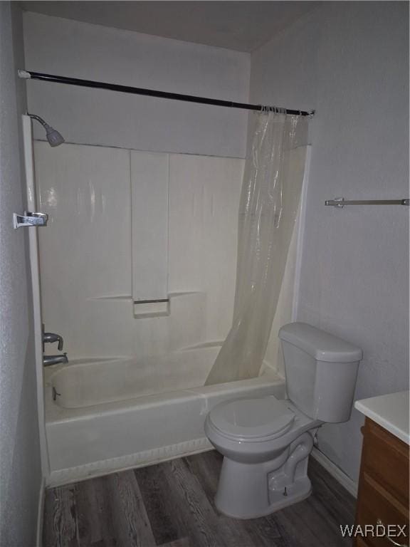 full bathroom with wood finished floors, shower / bath combination with curtain, toilet, vanity, and baseboards