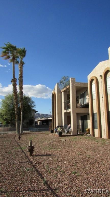 view of yard with fence and a balcony