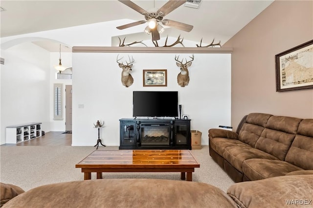 living room with carpet floors, visible vents, arched walkways, and lofted ceiling