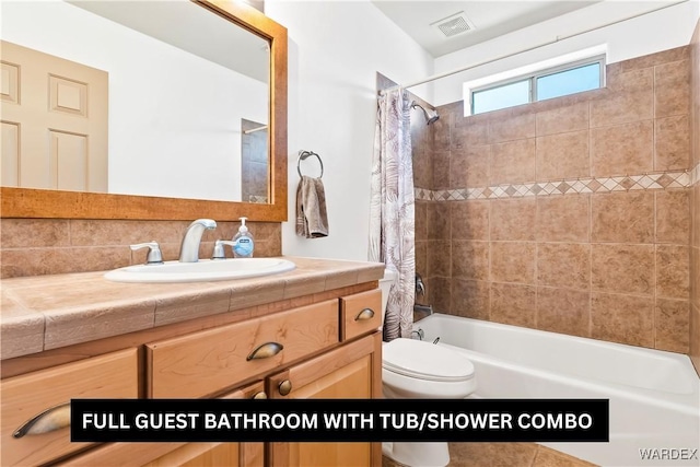 full bathroom with shower / bath combination with curtain, visible vents, vanity, and toilet