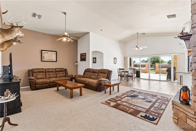 carpeted living area featuring arched walkways, visible vents, and ceiling fan