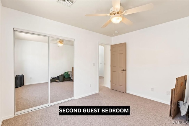 unfurnished bedroom featuring carpet floors, a closet, visible vents, and baseboards