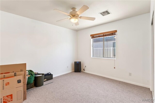 unfurnished room featuring a ceiling fan, light colored carpet, visible vents, and baseboards