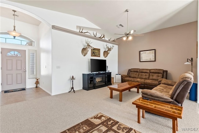 living area with light tile patterned floors, arched walkways, light colored carpet, a ceiling fan, and visible vents