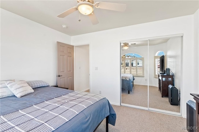 carpeted bedroom with baseboards, a ceiling fan, and a closet