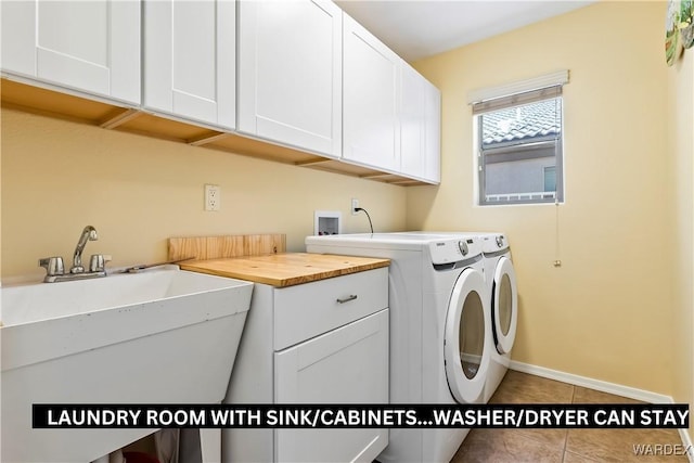 laundry room with cabinet space, a sink, tile patterned flooring, independent washer and dryer, and baseboards