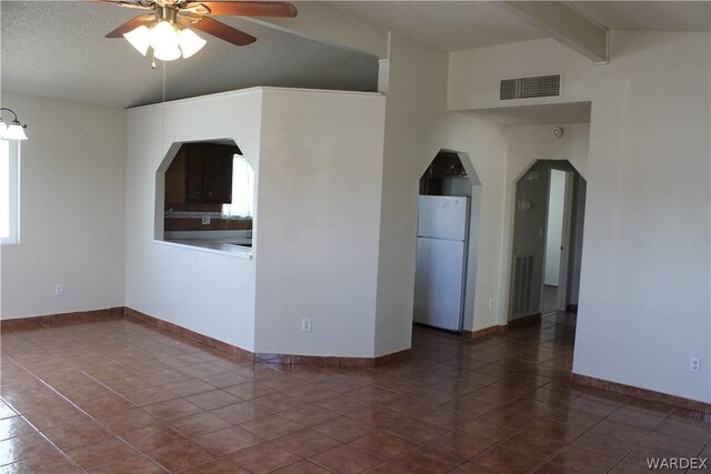 unfurnished room with arched walkways, vaulted ceiling with beams, visible vents, ceiling fan, and a textured ceiling